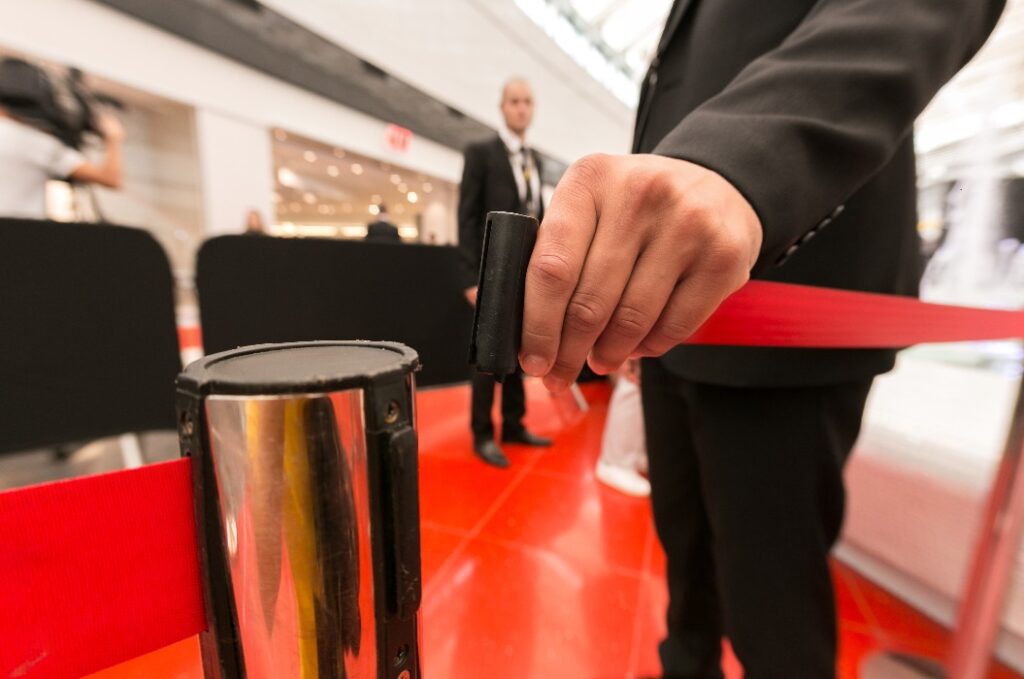 Ein Sicherheitsbeamter befestigt ein rotes Absperrband, das den Durchgang versperrt